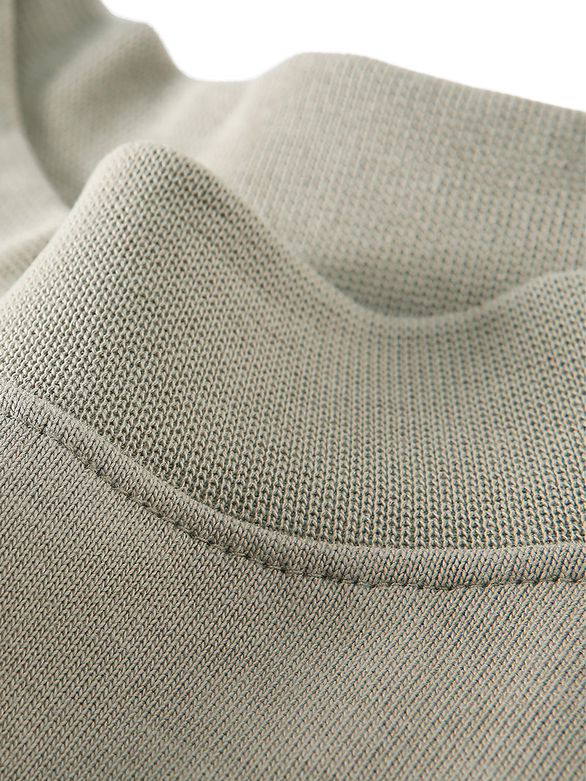 Close-up of a textured fabric with a visible seam on a light gray background