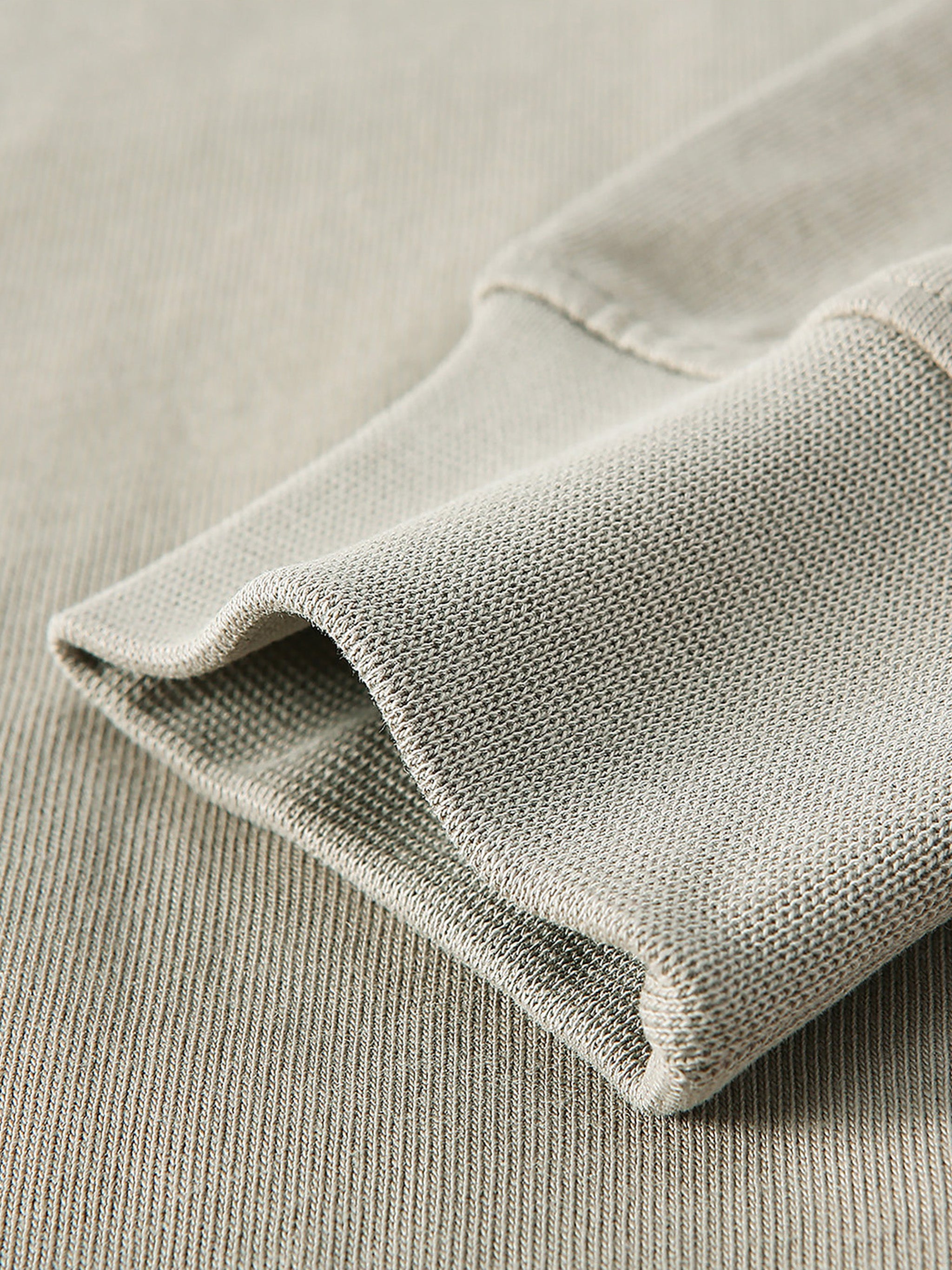 Close-up of a folded light gray fabric on a matching background