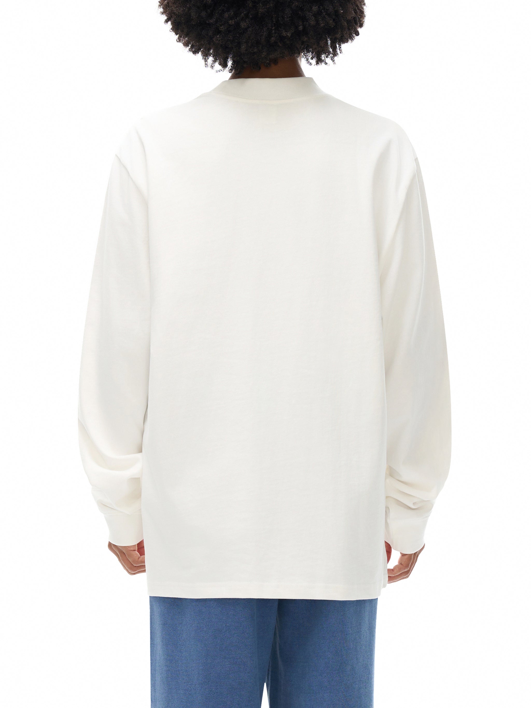 Person wearing a white sweatshirt with blue pants on a white background