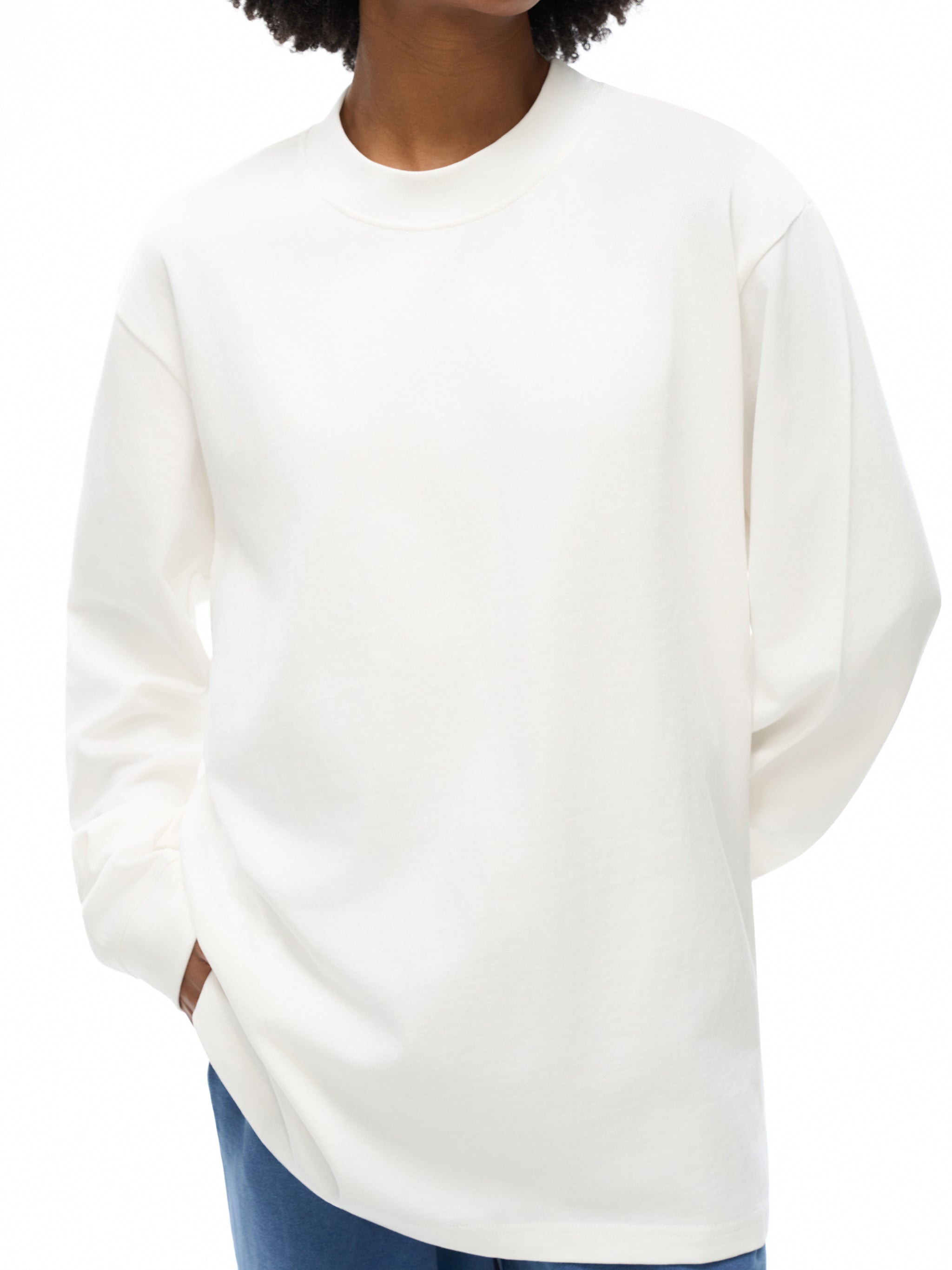 Person wearing a white sweater on a white background